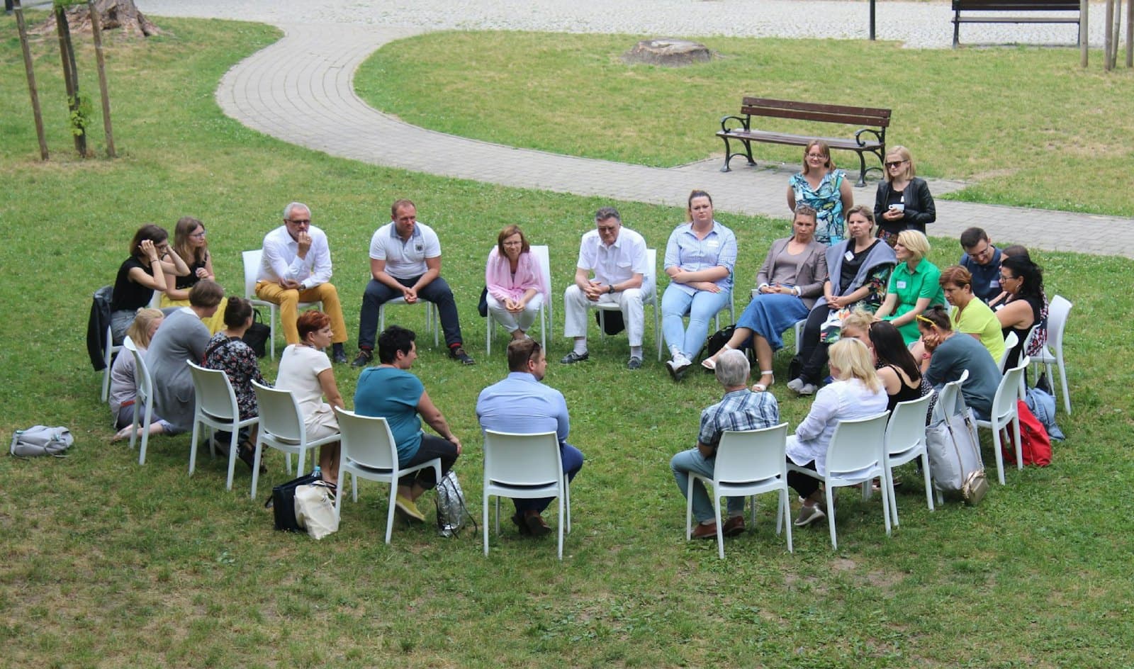 Une communauté réunie en cercle de chaises sur une pelouse